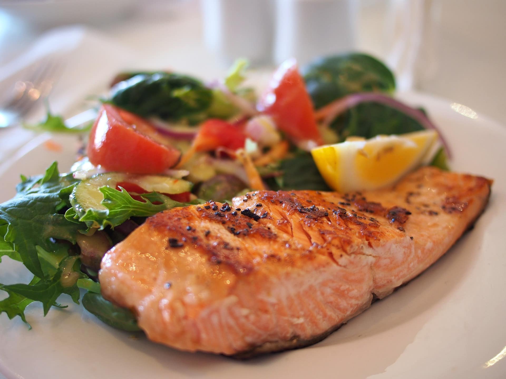 Une assiette du Menus de la semaine déjeuner et diner, mettant en valeur un filet de saumon joliment grillé, accompagné de légumes frais.